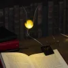 O lampă de lectură aurie care poate fi prinsă pe o carte Harry Potter