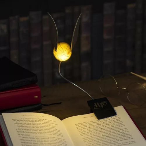 O lampă de lectură aurie care poate fi prinsă pe o carte Harry Potter